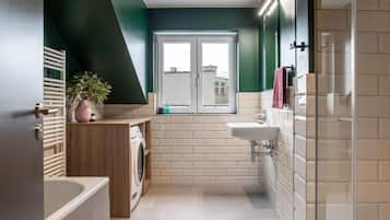Un bagno moderno con lavatrice, lavandino e finestra.