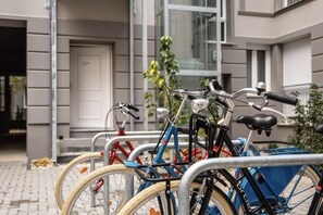 Varias bicicletas están estacionadas frente a un edificio con puerta y ventanas.