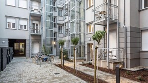 A multi-story residential building with balconies, a bike parking area, and a paved courtyard. - ipartment Berlin Mitte @HOME by Best Western (Berlin)