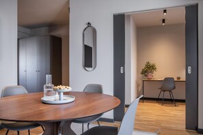 Un comedor moderno con una mesa redonda, sillas y una bandeja pequeña con comida.