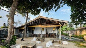 Een restaurant aan het strand met terras, zwembad en overdekte patio.