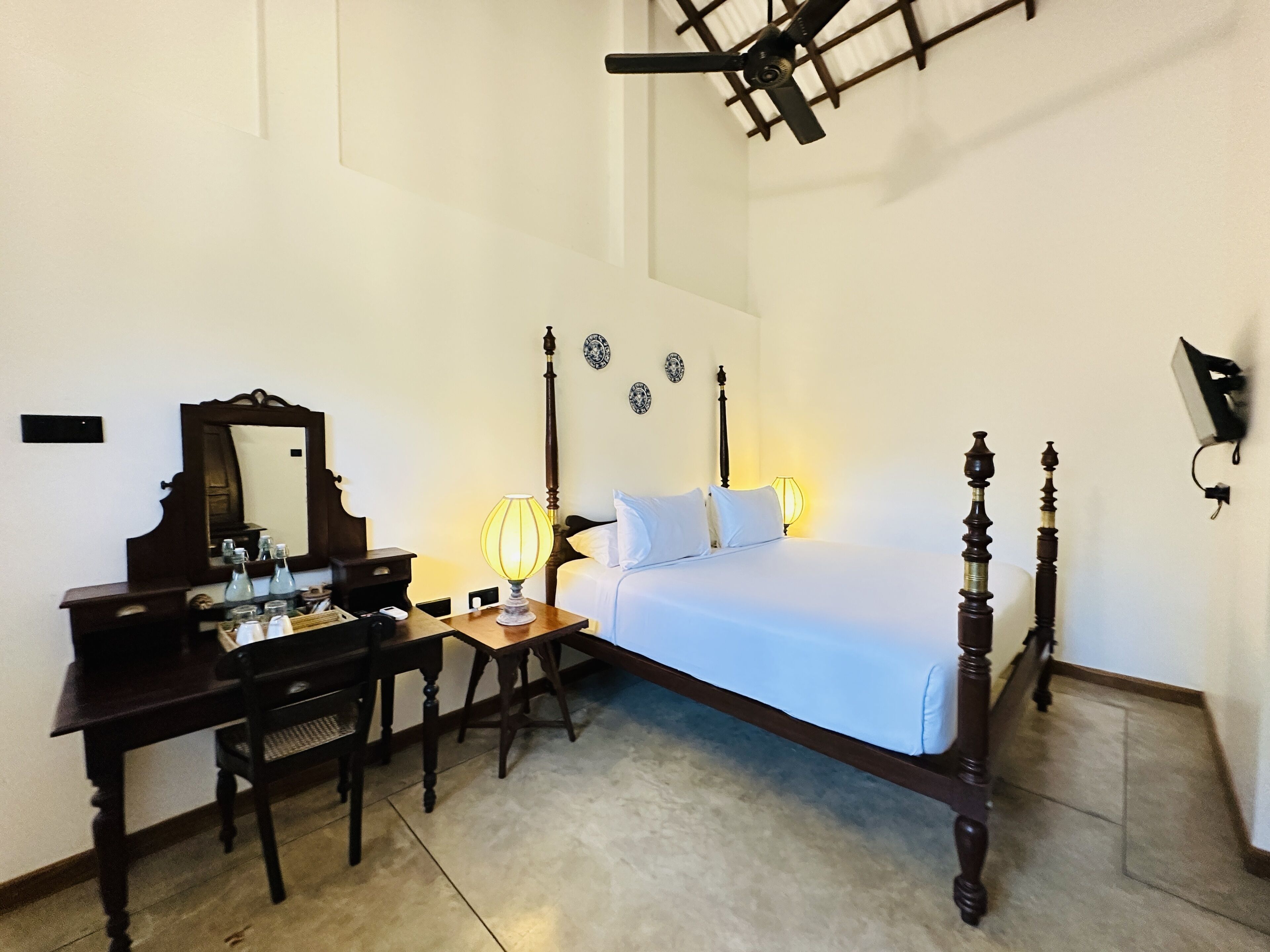 Ein Schlafzimmer mit einem Bett, einem Nachttisch, einer Lampe und einem Schreibtisch mit Stuhl.