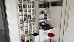 Une salle d’étude équipée d’une bibliothèque, d’un bureau et d’une chaise rouge.