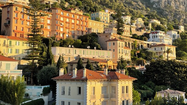 Une ville construite sur une colline, avec des bâtiments érigés en terrasses, dotés de balcons et présentant un mélange de styles architecturaux.