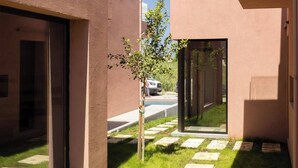 Un edificio moderno con ampie vetrate e un vialetto lastricato.