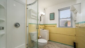 A bathroom with a glass shower enclosure, a toilet, and a sink. - Two bedroom ocean block condo in a great location! (Ocean City)