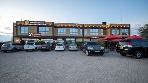 A hotel with a sign reading "Eaglesvale Resort" and several cars parked in front. - Eaglesvale Hotel (Naivasha)