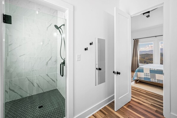 A modern bathroom with a glass shower enclosure and a separate shower area. - White House on Shell Mountain | Pool & Epic Views (Sevierville)