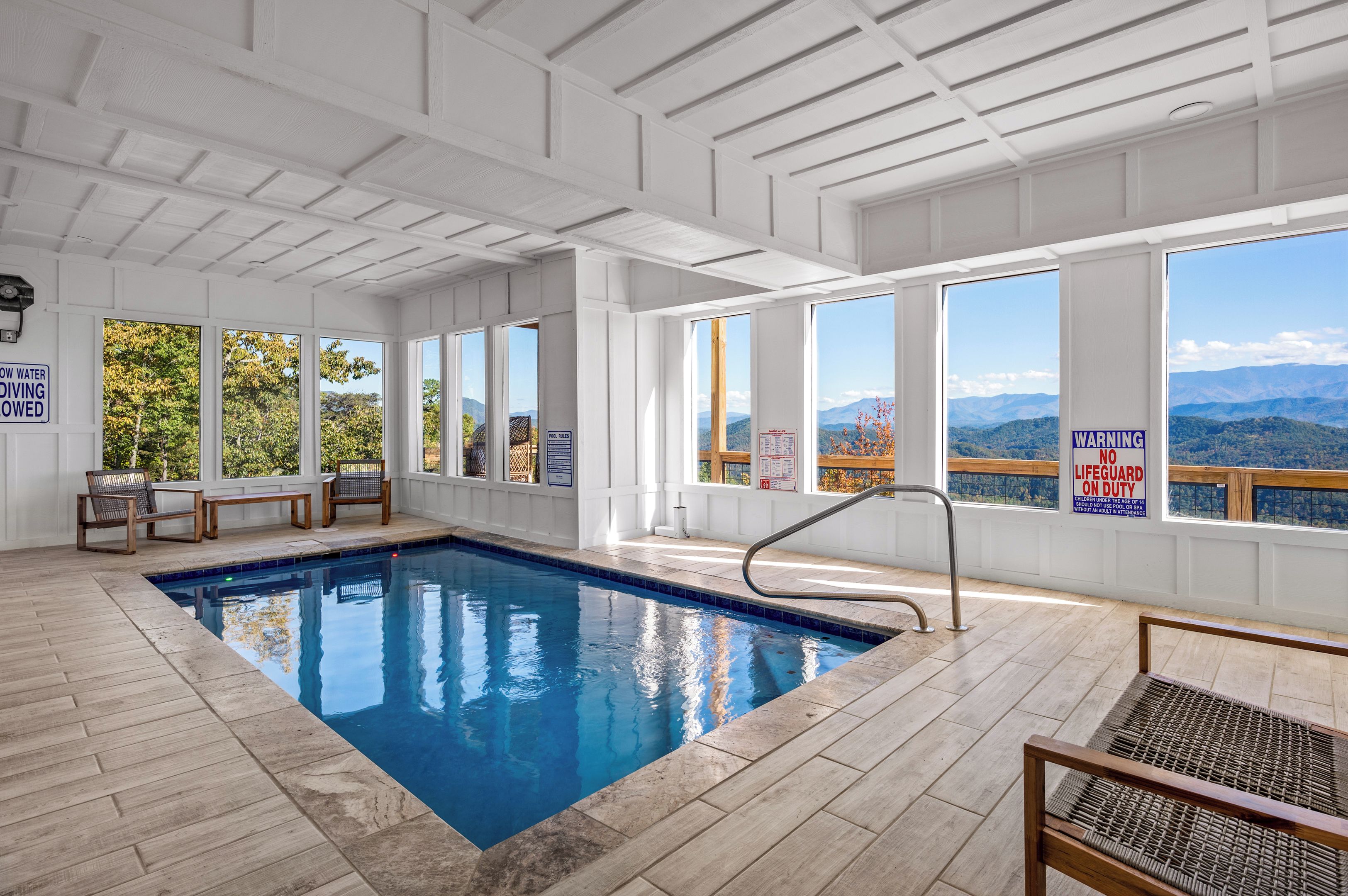 An indoor swimming pool with clear views of mountains through large windows.