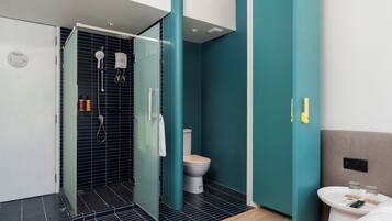 Un baño moderno con ducha, inodoro y lavamanos.