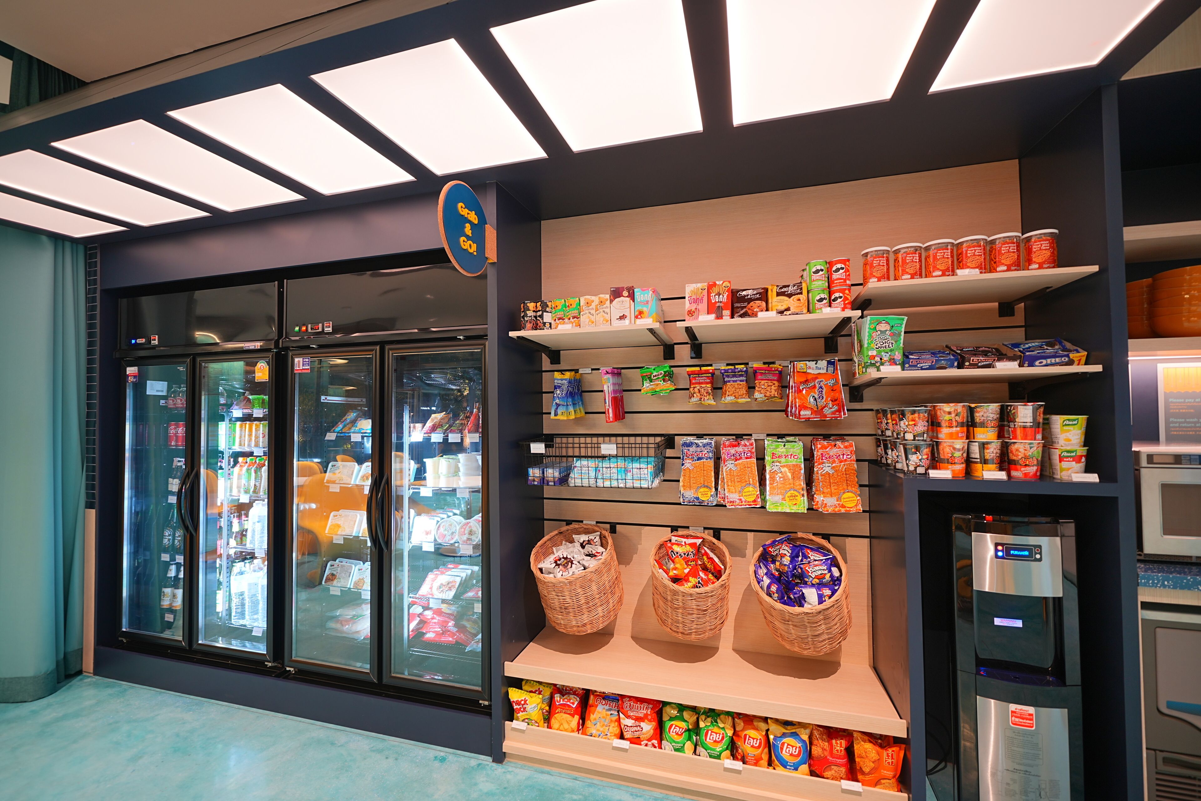 A grocery store with refrigerated sections, shelves stocked with snacks, and a self-serve beverage machine.