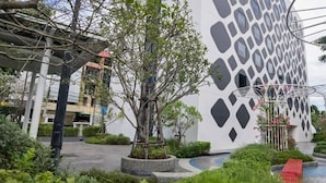 A modern building with a geometric facade, surrounded by landscaped gardens and a small water feature. - GO Hotel Chonburi at Central Chonburi (Chonburi)