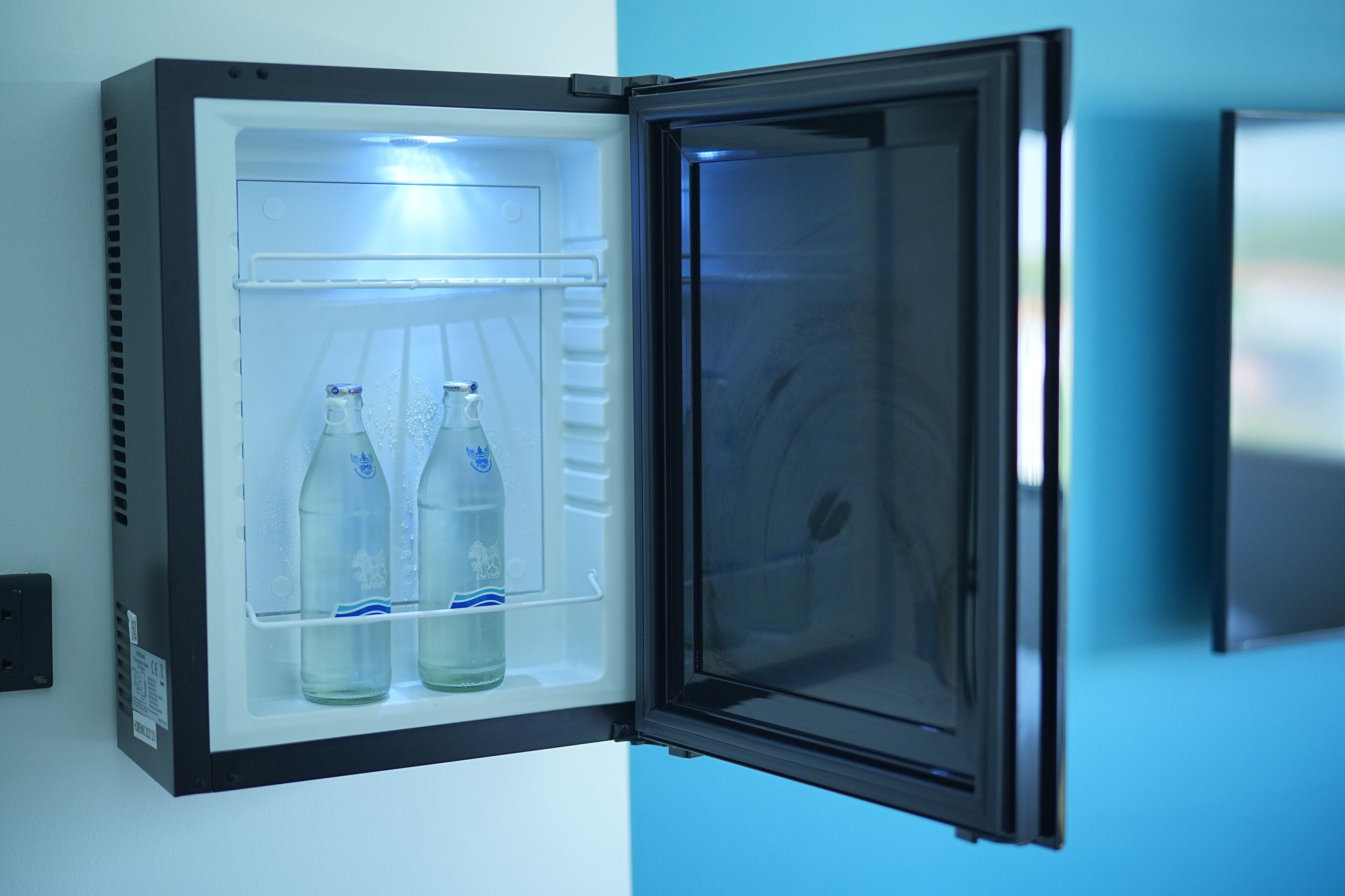 Ein geöffneter Kühlschrank, darin zwei Flaschen zu sehen.