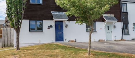 A two-story building with a blue door and a sign reading "Spinnaker."