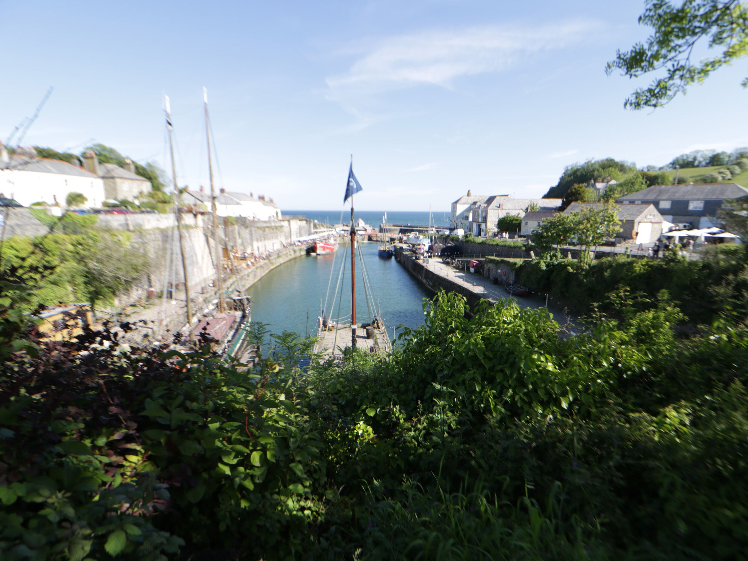A harbor with boats, a flag, and buildings along the water.