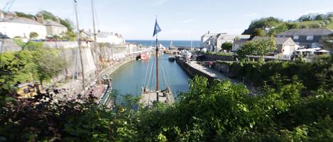 A harbor with boats, a flag, and buildings along the water.