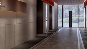 A modern hallway with a herringbone floor pattern, wooden panel walls, and a glass door leading to an outdoor area.