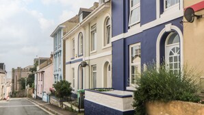 Une rangée de maisons mitoyennes aux styles architecturaux et aux couleurs bien distincts.