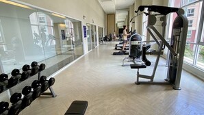 A spacious gym with treadmills, weight machines, and free weights. - Grande Caribbean by PSR (Pattaya)
