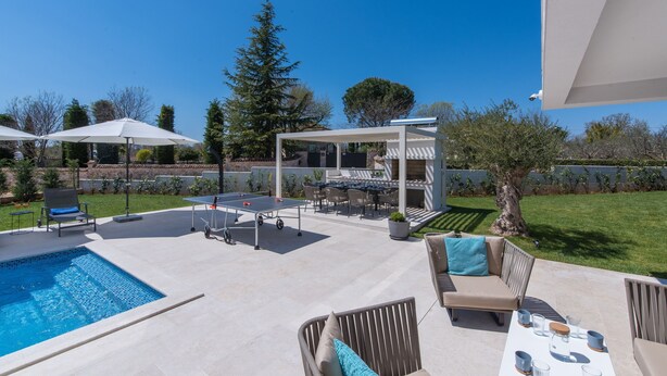 A backyard with a swimming pool, outdoor seating, and a pergola. - Frani in Pore With 4 Bedrooms and 4 Bathrooms (Porec)
