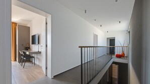 Een modern interieur met een trap, een eethoek met stoelen en een wandtelevisie.