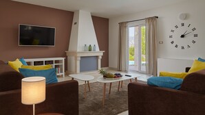 A modern living room with brown sofas, a white coffee table, a fireplace, and a large wall clock.