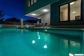 A swimming pool with lounge chairs, a modern building with large windows, and a visible kitchen area. - Kastel Two in Ka tel Kambelovac (Kastela)