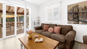A modern living room with a brown sofa, a wooden coffee table, and a painting of a bridge. - Kastelir in Ka Telir (Kastelir-Labinci)