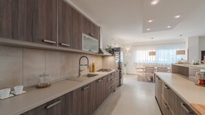 Una cocina moderna con gabinetes de madera, un lavamanos de acero inoxidable y un horno empotrado.