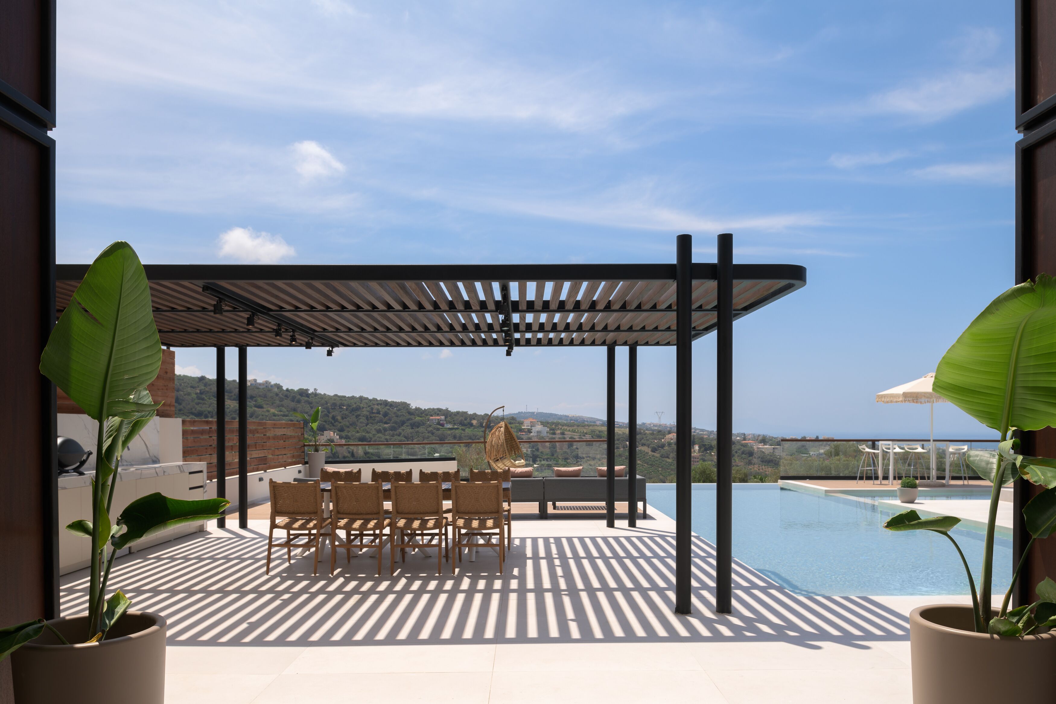 A rooftop terrace with a pool, outdoor seating, and a pergola.