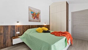 A bedroom with a bed, a wall-mounted artwork, a wardrobe, and a bedside table. - Casa Mara in Tokovci (Svetvincenat)