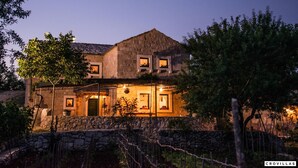 A stone building with multiple windows and a warm interior light. - Ognjistar in Zmijavci (Zmijavci)