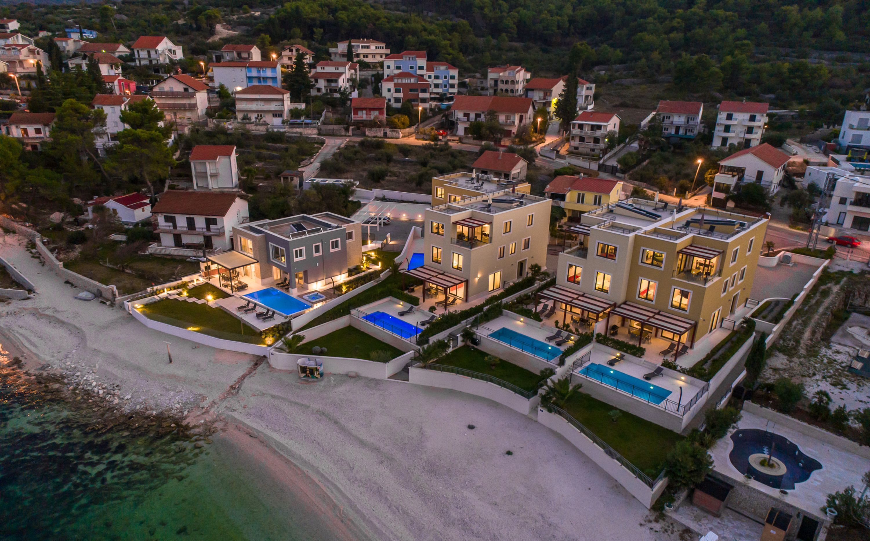 A coastal residential area with modern buildings, a beach, and clear waters. - Acadia C in Slatine With 6 Bedrooms and 6 Bathrooms (Split)