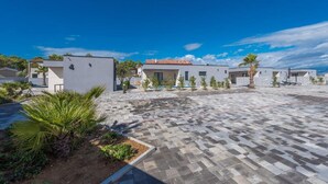 A modern residential complex with white buildings, a paved courtyard, and small trees. - M5 in Vir With 2 Bedrooms and 2 Bathrooms (Vir)