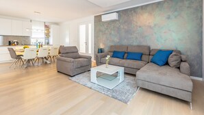 A modern living room with a sofa, coffee table, and dining area. - Roko in Malinska With 4 Bedrooms and 2 Bathrooms (Malinska-Dubasnica)