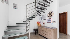 A modern staircase with glass steps and metal railings, a wooden bench, a desk with papers, and a life preserver decoration on the wall. - Fantasia in Barban With 4 Bedrooms and 2 Bathrooms (Marcana)