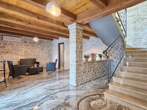 A spacious living area with a stone wall, wooden beams, and a marble floor. - Patrick in Pazin With 4 Bedrooms and 4 Bathrooms (Pazin)