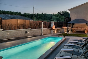 A swimming pool with lounge chairs, a barbecue area, and a stone wall. - Patrick in Pazin With 4 Bedrooms and 4 Bathrooms (Pazin)