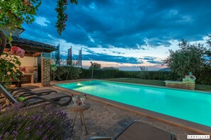 A swimming pool with lounge chairs and a table, surrounded by a garden with lavender and roses. - Bella Vista in Barat (Visnjan)