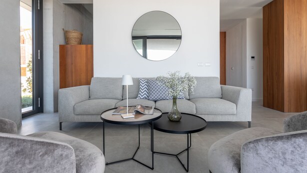A modern living room with a grey sofa, two round coffee tables, and a large round mirror on the wall. - Loft Hvar in Hvar With 3 Bedrooms and 1 Bathrooms (Hvar)