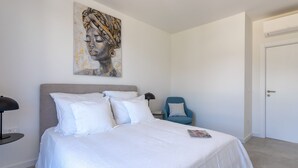 A bedroom with a bed, a chair, and a painting on the wall. - Loft Hvar in Hvar With 3 Bedrooms and 1 Bathrooms (Hvar)