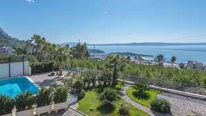 Zona de piscina con vista al mar y a las montañas.