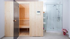 Un baño moderno con cabina de ducha de vidrio, sauna de madera y panel de control en la pared.