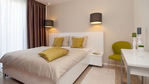 A modern bedroom with a large bed, bedside tables, a desk, and a chair. - More in Okrug Gornji (Okrug)