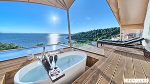 A wooden deck with a hot tub, lounge chairs, and a view of the sea. - Honeymoon in Murter With 1 Bedrooms and 1 Bathrooms (Tisno)