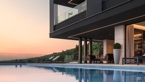 A modern hotel with a pool, outdoor seating, and a view of the landscape. - Panoramica in Koroma no (Rasa)