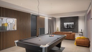 A modern living room with a pool table, a sofa, and a television. - Panoramica in Koroma no (Rasa)