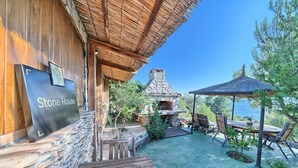 A stone house with a stone fireplace, outdoor seating, and a view of the sea. - Stone in Murter With 1 Bedrooms and 1 Bathrooms (Tisno)
