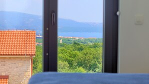 Ein Zimmer mit Blick auf eine Küstenstadt, ein Ziegeldach und eine Steinmauer.