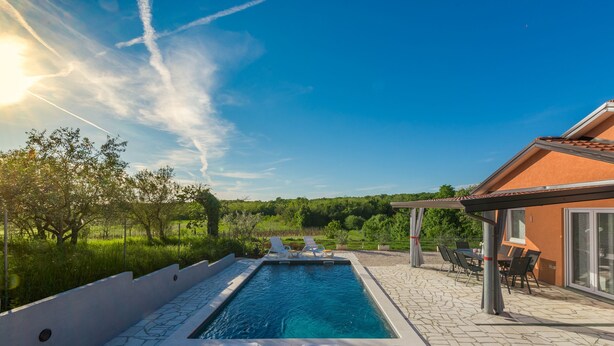A swimming pool with lounge chairs and a covered patio area. - Pendolina in Buje With 3 Bedrooms and 1 Bathrooms (Buje)